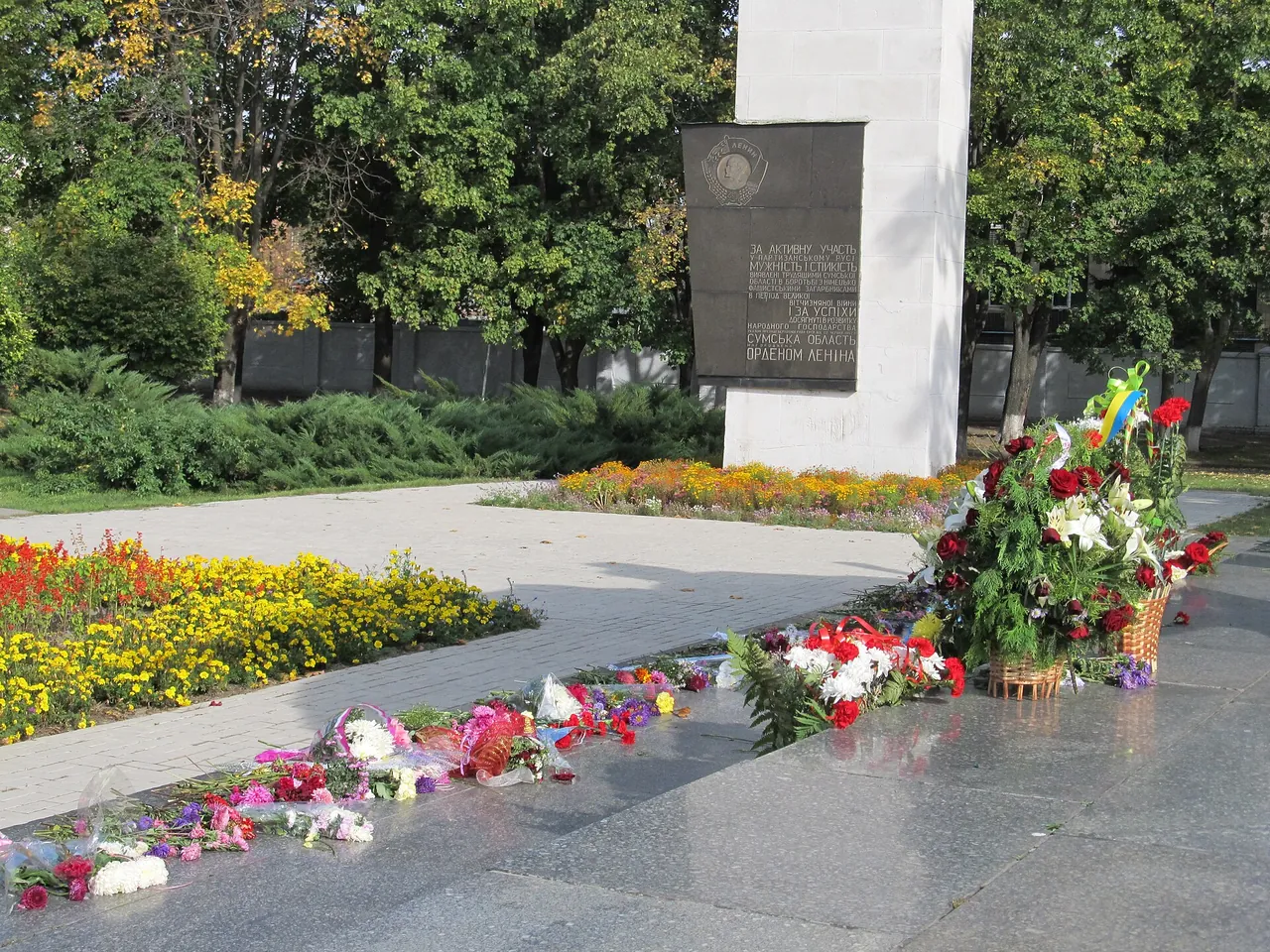 Квіти біля 22-метрової стели монумента «Слава героям Сумщини» на Привокзальній площі